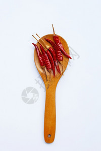 白色背景的木勺上红辣椒图片