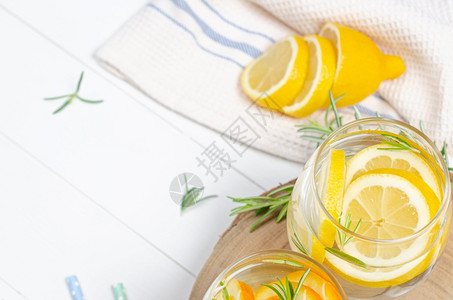 柠檬汁在罐子里柠檬水和露天桌上有迷迭香的柠檬图片