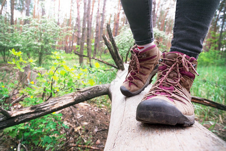 近身远足靴女孩游客在原木上踏步积极生活方式图片
