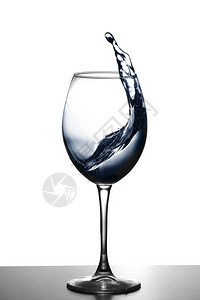 在玻璃酒杯中喷水在发光背景上喷水在酒杯中以透明方式喷水在酒杯中食物品在玻璃杯中喷水物品图片