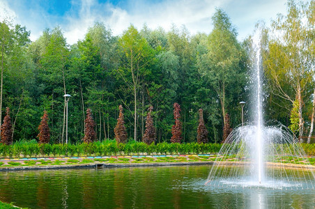 小喷泉和游泳池在一个公园里有草和树木图片