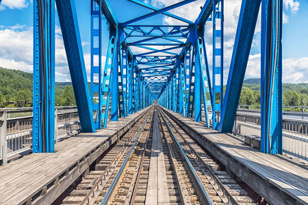 通过穿越河流的蓝色铁路桥工业地貌图片