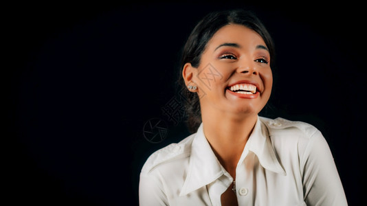 一位美丽快乐的年轻女士肖像摄影棚黑色背景图片