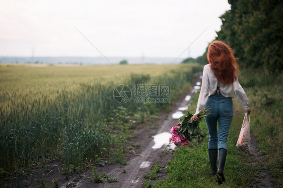带着花束的女孩走在乡间的路上图片
