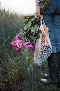 一个女孩带着束花和袋带面包的绳子村里春天的心情图片
