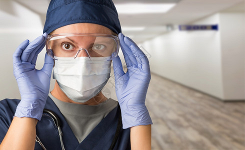 女医生或护士在院走廊戴面罩和防护装备图片