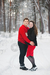 快乐的情侣在冬季的森林里拥抱图片