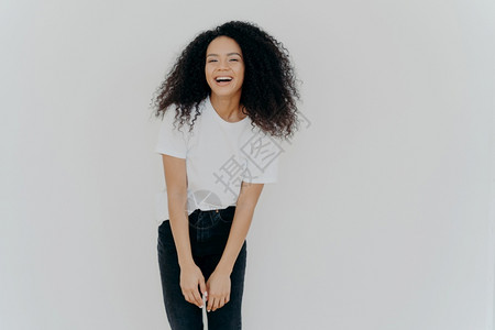欢乐的非裔美国妇女快乐地笑着穿随意衣感觉很好穿着白色背景的姿势空的广告内容充满了活力图片