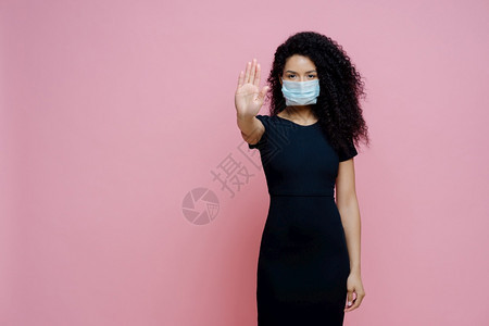 19次爆发疾卷发的少数民族妇女照片手掌停止势拒绝冠状戴保护无菌面具避免穿黑色衣服图片