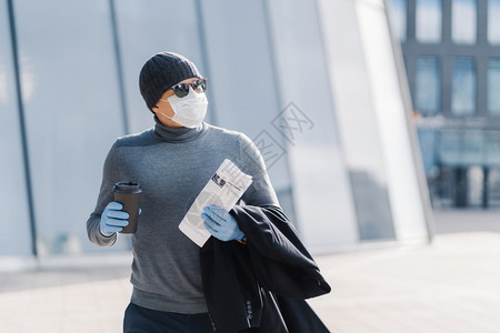 男人在户外行走保护流感冠状传播喝咖啡抛开面纱阅读报纸遵循隔离规则2019ncov流行图片