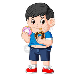 快乐可爱的小男孩正在吃两个甜圈图片
