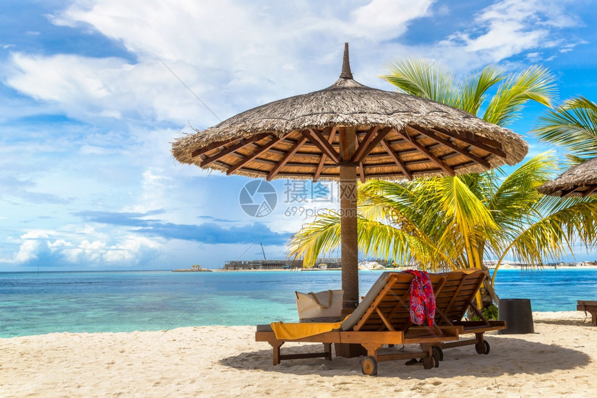 甲状腺病June24018年6月4日夏季在热带海滩的甲状腺病热带沙滩上木制防晒雨和伞图片