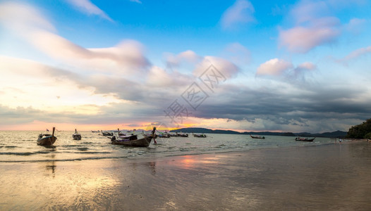日落时在夏泰国海滨的阿诺南滩传统长尾船全景图片