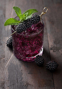 清凉的夏季鸡尾酒黑莓装在晶玻璃里冰块和薄荷装在木本底图片