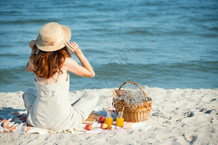 戴着帽子的女孩和篮带着面包苹果和汁野餐图片