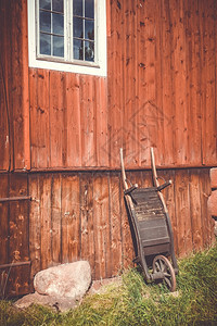 农场墙上的旧木制手推车图片