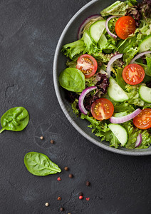 新鲜健康素食蔬菜沙拉番茄和黄瓜红洋葱菠菜图片