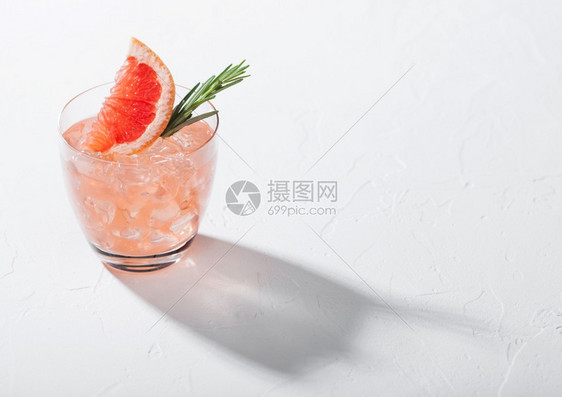 以冰块水果切片和白色背景的迷迭香为杯子文本空间图片