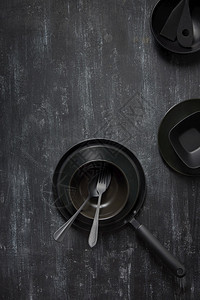 黑陶瓷锅叉子和勺的餐桌厨房设备颜色背景相同复制空间顶部视图晚餐桌和黑色炊具颜背景相同图片