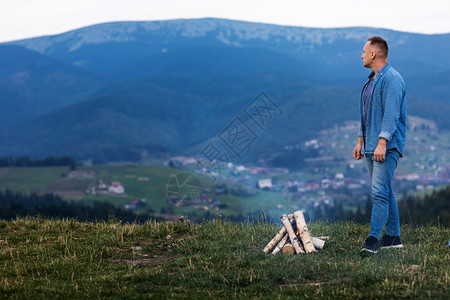 年轻男子站在山顶的夜空下燃烧着的火焰中活跃生方式概念活跃的生方式概念图片