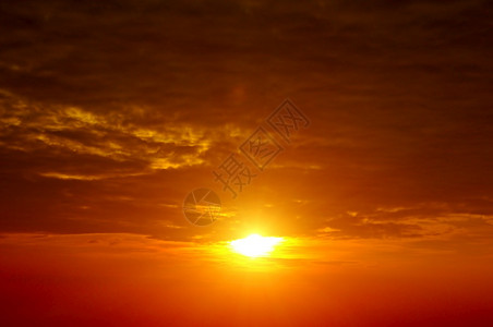 太阳在夜晚用云朵定下橙色的天空背景图片