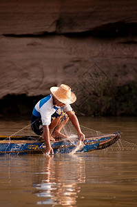 2010年5月17日泰国乌汶湄公河旧木船上的当地泰国渔民和渔网印度支那地区简单迷人的南洋乡村生活图片