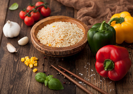 碗里煮着长的麦子巴斯马蒂蔬菜米木本底有棍和辣椒玉米加仑巴西尔和红柿图片