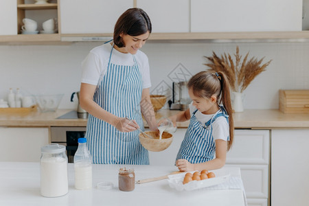母亲和女儿在厨房一起烤面包图片