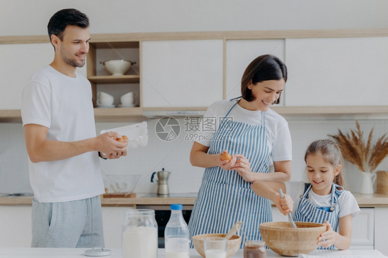 可爱女儿和妈妈一起做饭享受家庭气氛图片