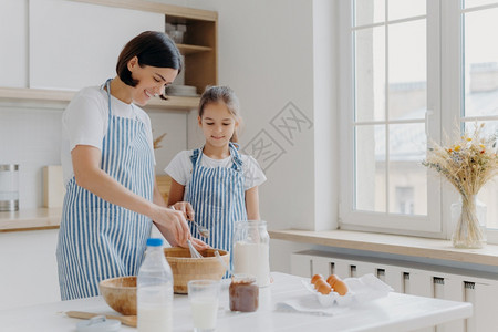 坐在厨房的桌子旁做早餐的母女图片