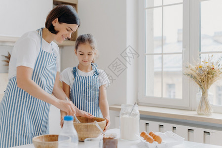 坐在厨房的桌子旁做早餐的母女图片