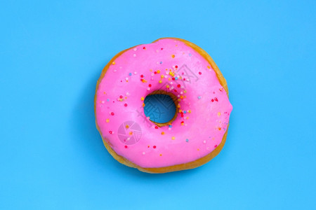 蓝色背景上的粉红甜圈顶视图图片