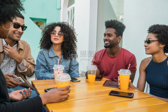 afro朋友一起玩得开心边喝新鲜果汁一边享受美好时光的肖像图片