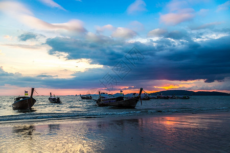 日落时在夏泰国阿奥南海滨的滩传统长尾船图片