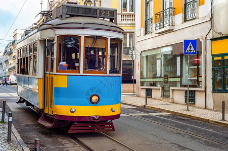 Lisbon老城的狭窄铺面街道上古老的电车道有典型的建筑Porugal图片