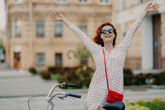 漂亮年轻女子在户外骑自行车开心的舒展双臂图片