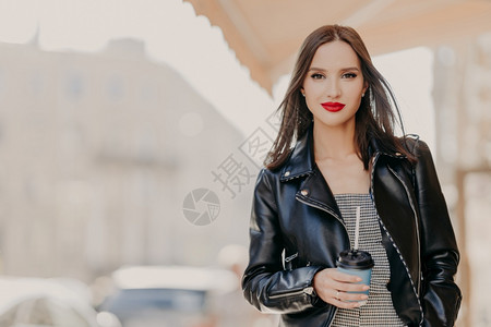 穿着时髦的皮夹克喝一次咖啡在城市游荡享受休闲时间喝酒概念图片