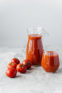 熟的红番茄接近两杯美味的番茄汁白色背景健康蔬菜图片