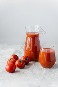 熟的红番茄接近两杯美味的番茄汁白色背景健康蔬菜背景图片