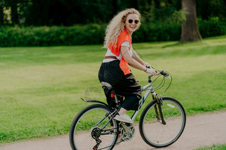 快乐女子骑着自行车在公园内图片