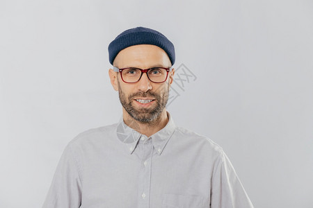 笑男人的横向观点是戴着眼镜帽子和衬衫对好消息感到满意以白色背景为模型未经粉饰的嬉皮士欢呼着新的购买时装概念背景图片