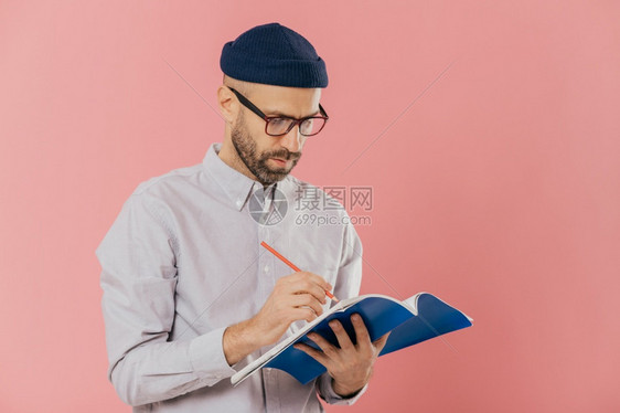 中年男人手上拿着一本蓝色的笔记本在做笔记图片