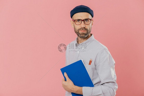 中年男人手上拿着一本蓝色的笔记本图片