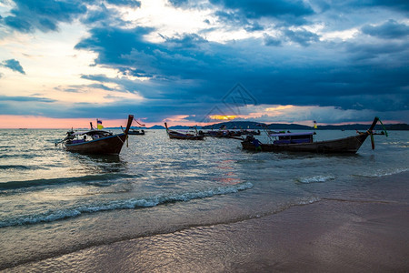日落时在夏泰国阿奥南海滨的滩传统长尾船图片