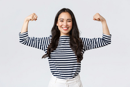 强烈而自信的亚洲女柔韧biceps吹她的完美形状吹在注册体育馆会员资格之后吹肌肉运动和感觉强烈生活方式人们的情绪和随意概念强烈而图片