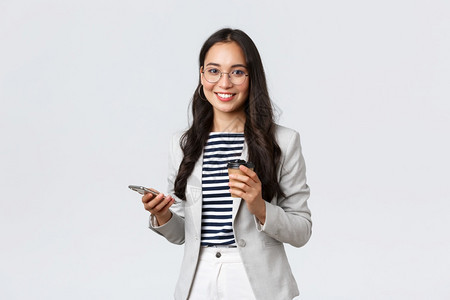 戴眼镜吃午餐喝咖啡使用移动电话商业金融和就成功女企家概念图片