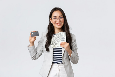 商业金融与就企家金钱概念成功的亚洲女商人展示如何增加收入持有信用卡和金钱微笑的相机图片
