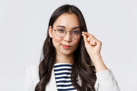 充满自信的年轻女亚洲商人修理眼镜寻找坚定的准备好签署交易的年轻女商人业金融和就女成功的企业家概念充满自信的年轻女商人修理眼镜寻找图片