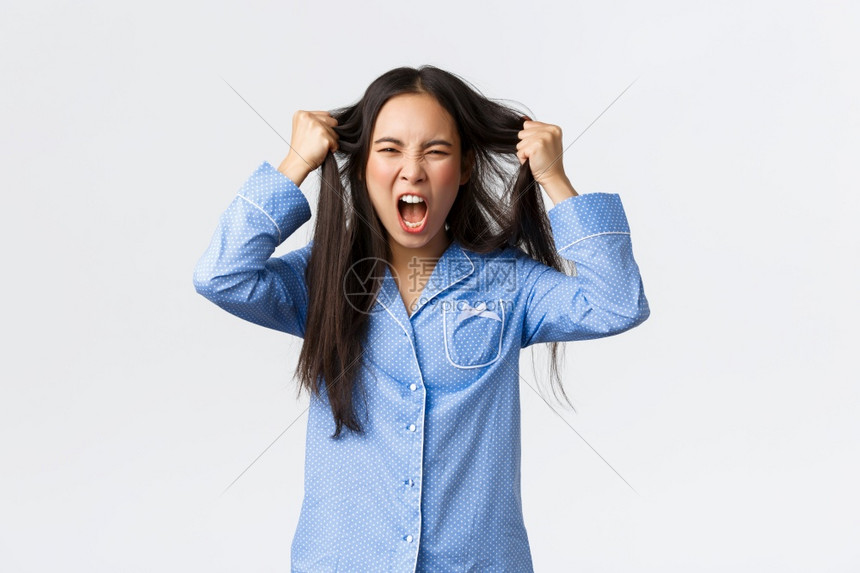 愤怒和的韩国女孩身穿蓝色睡衣头部扯发尖叫愤怒沮丧