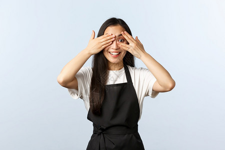 咖啡馆小企业和开办概念热情可爱的韩国咖啡店女馆工作人员微笑用手掌遮住眼睛用手指偷看有趣的新促销咖啡馆热情可爱的韩国咖啡店工作人员图片
